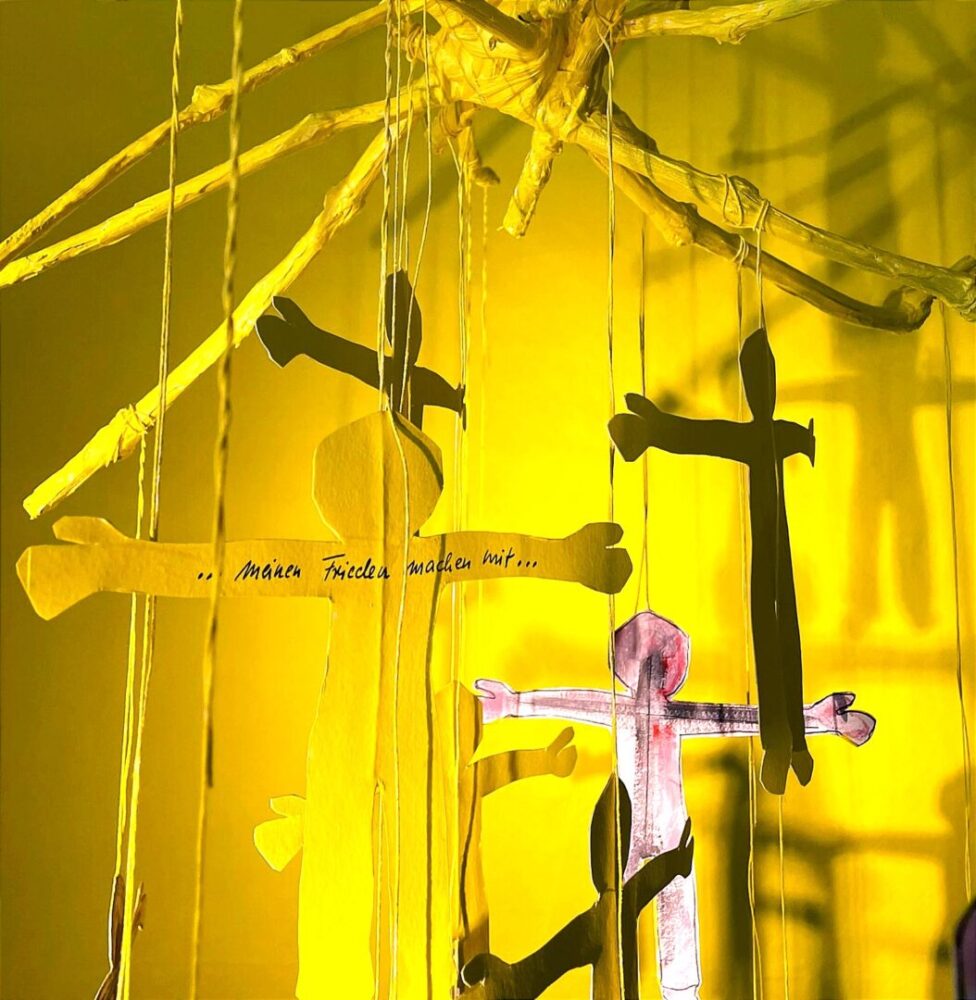 Ausschnitt/close-up von Mobile als Teil einer Installation zum Thema Frieden mit sich selbst finden, Figuren, die große Schatten werfen